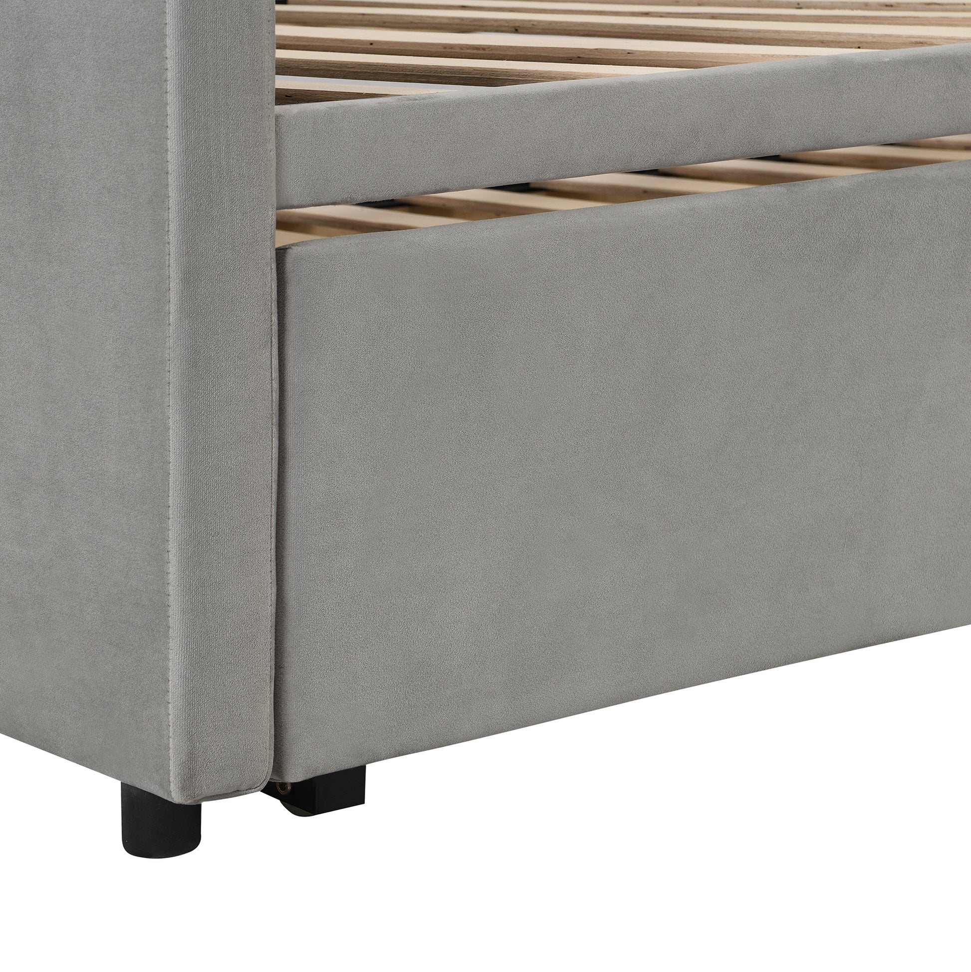 Gray velvet upholstered bed frame detail with wooden slats