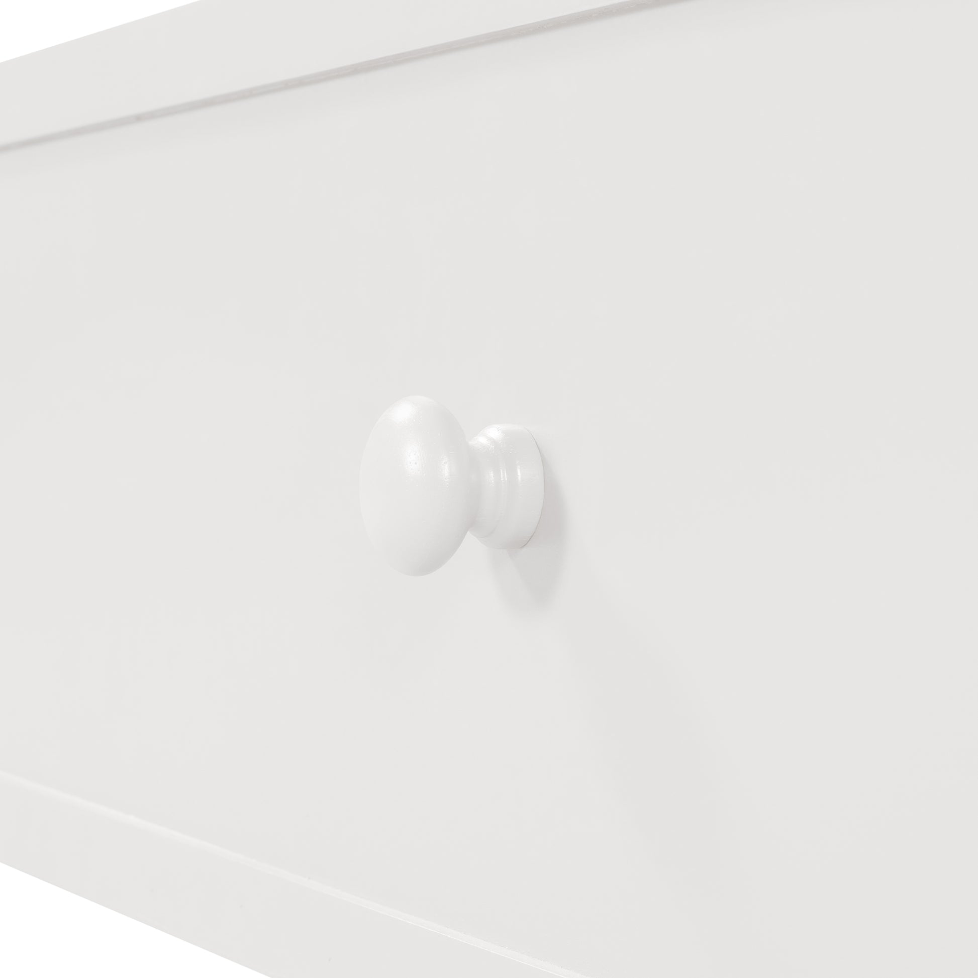 White wooden knob on a clean white drawer front perfect for childrens furniture