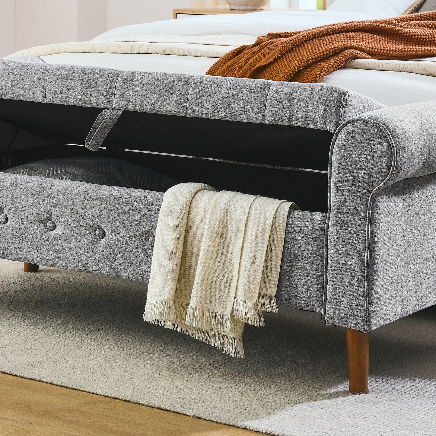 Grey fabric storage bed frame with open compartment and rolled arms
