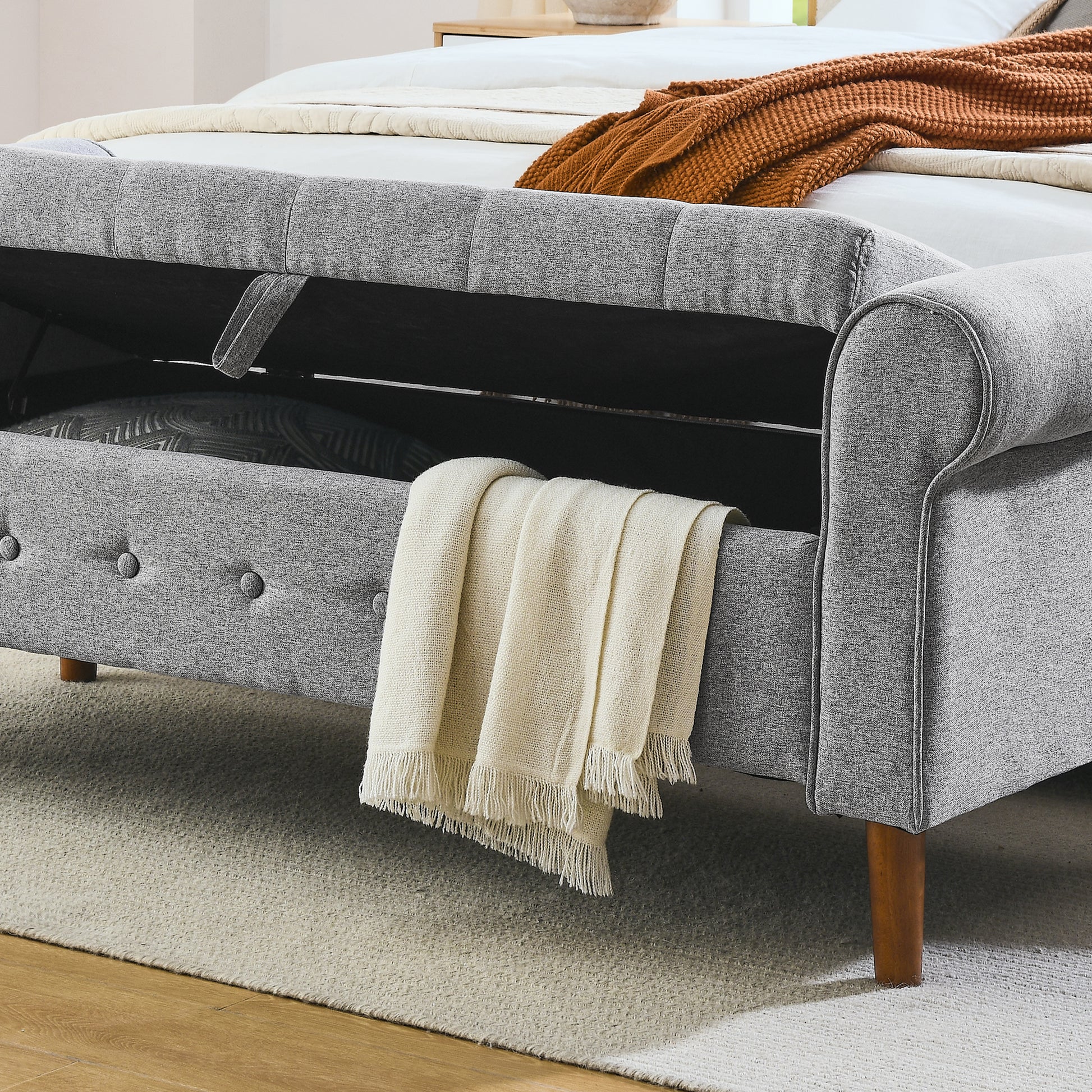 Grey fabric storage bed frame with open compartment and rolled arms