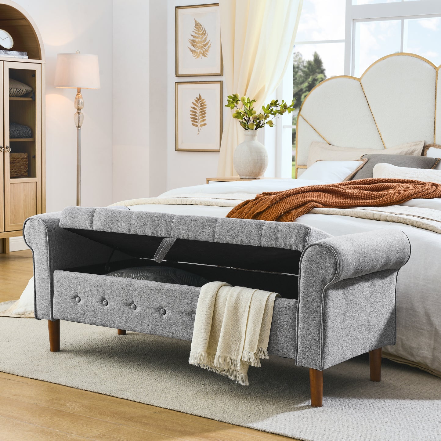 Grey upholstered storage bench with tufted detail and wood legs