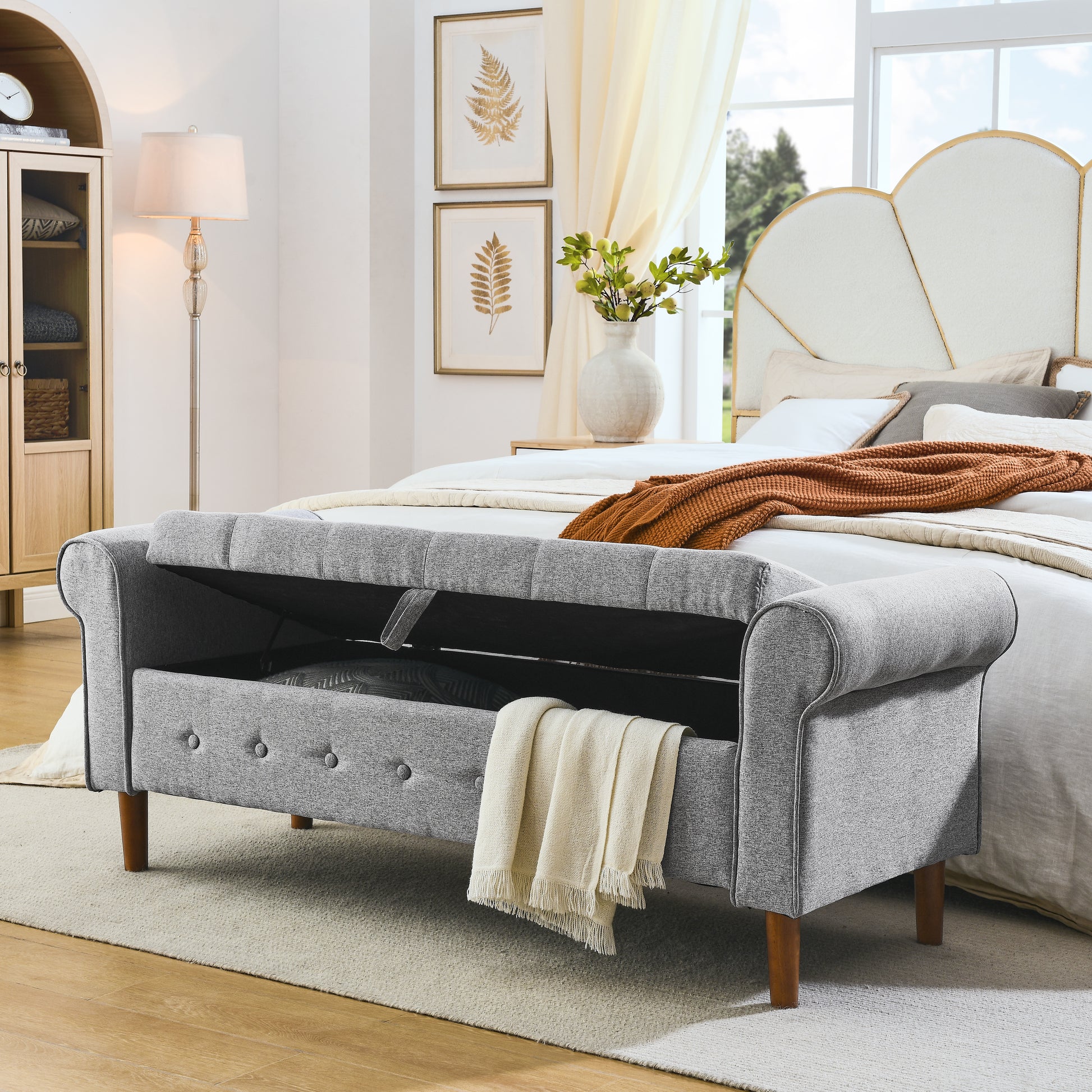 Grey upholstered storage bench with tufted detail and wood legs