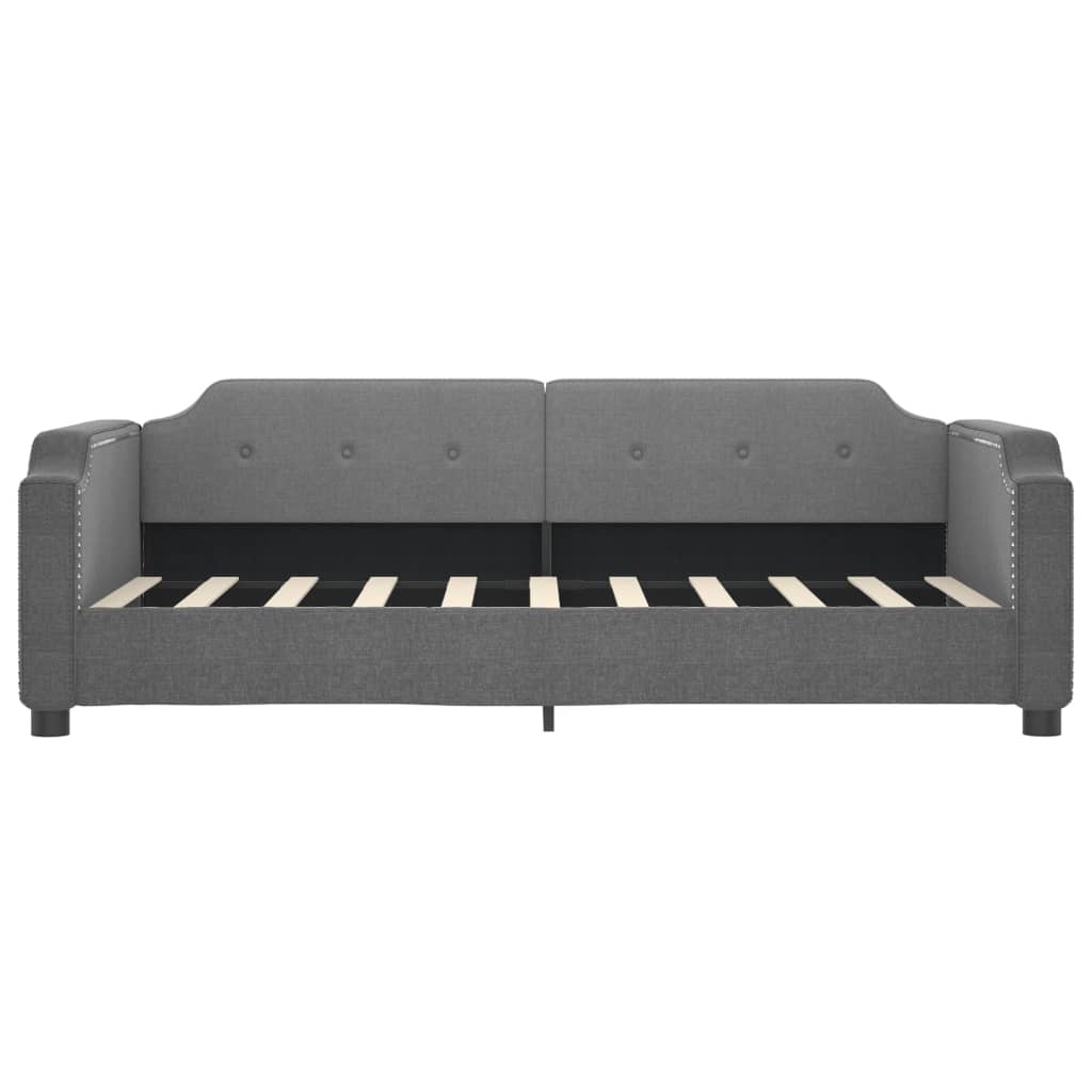 Dark grey upholstered daybed with button tufting and silver nailhead trim