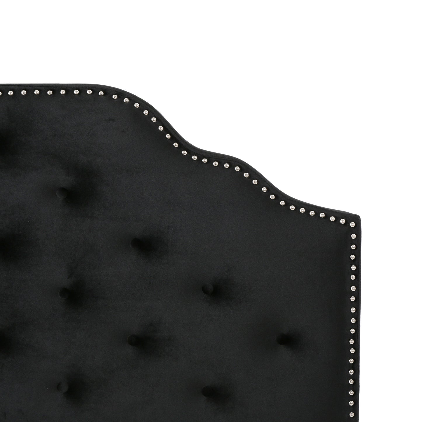 Closeup of black velvet headboard with diamond tufting and silver nailhead trim