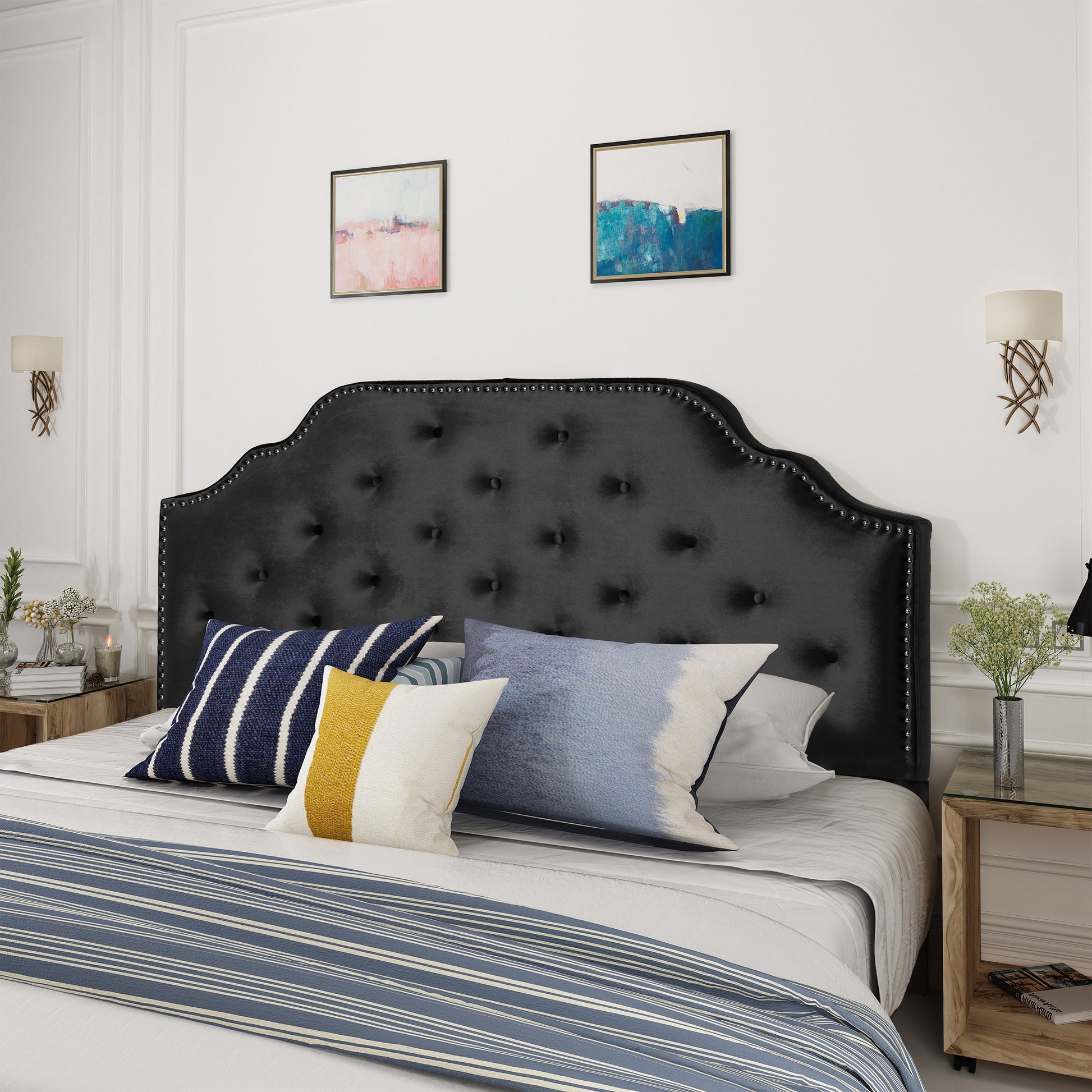 Black velvet tufted headboard with silver nailhead trim providing elegant bedroom style