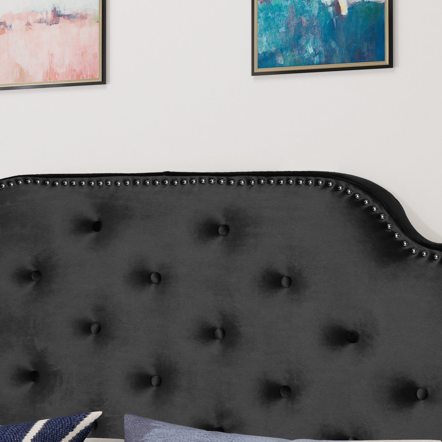 Black velvet tufted headboard with silver nailhead trim for a luxurious bedroom