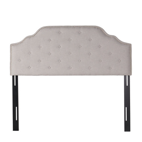 Tufted beige fabric headboard with nailhead trim and adjustable black metal legs