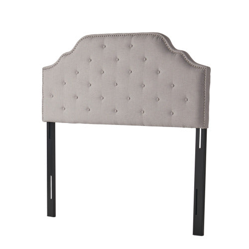 Tufted linen headboard with silver nailhead trim and black metal legs