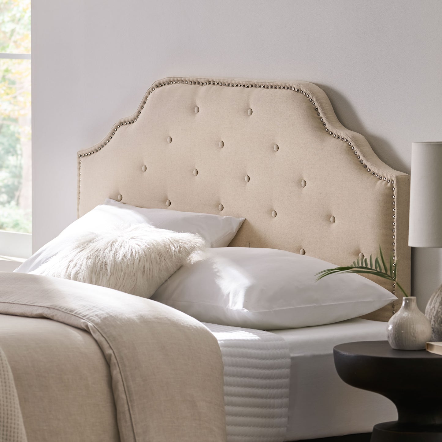 Tufted cream linen headboard with nailhead trim