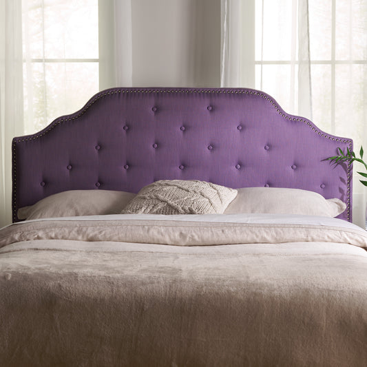 Tufted purple fabric headboard with nailhead trim