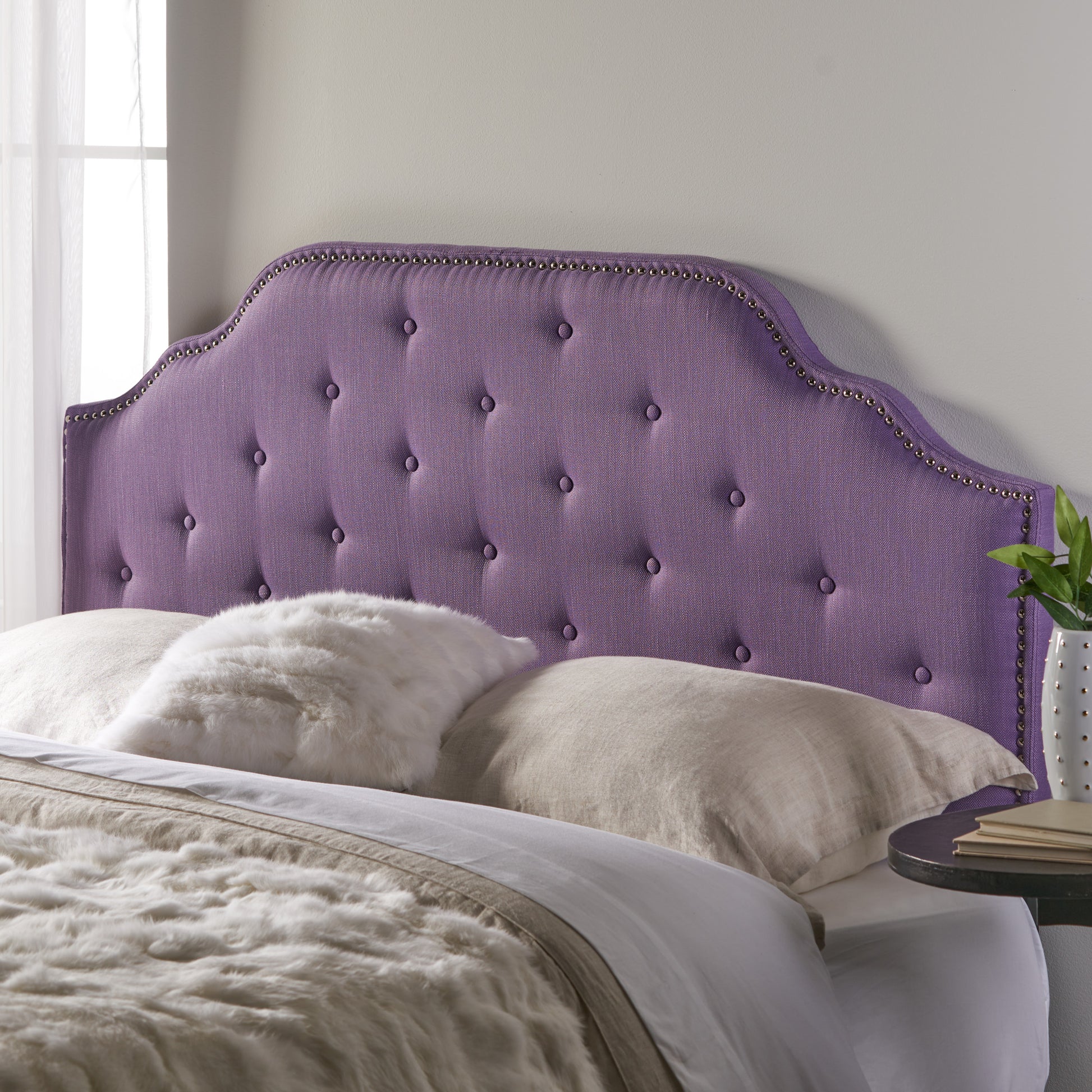 Purple fabric headboard with button tufting and silver nailhead trim