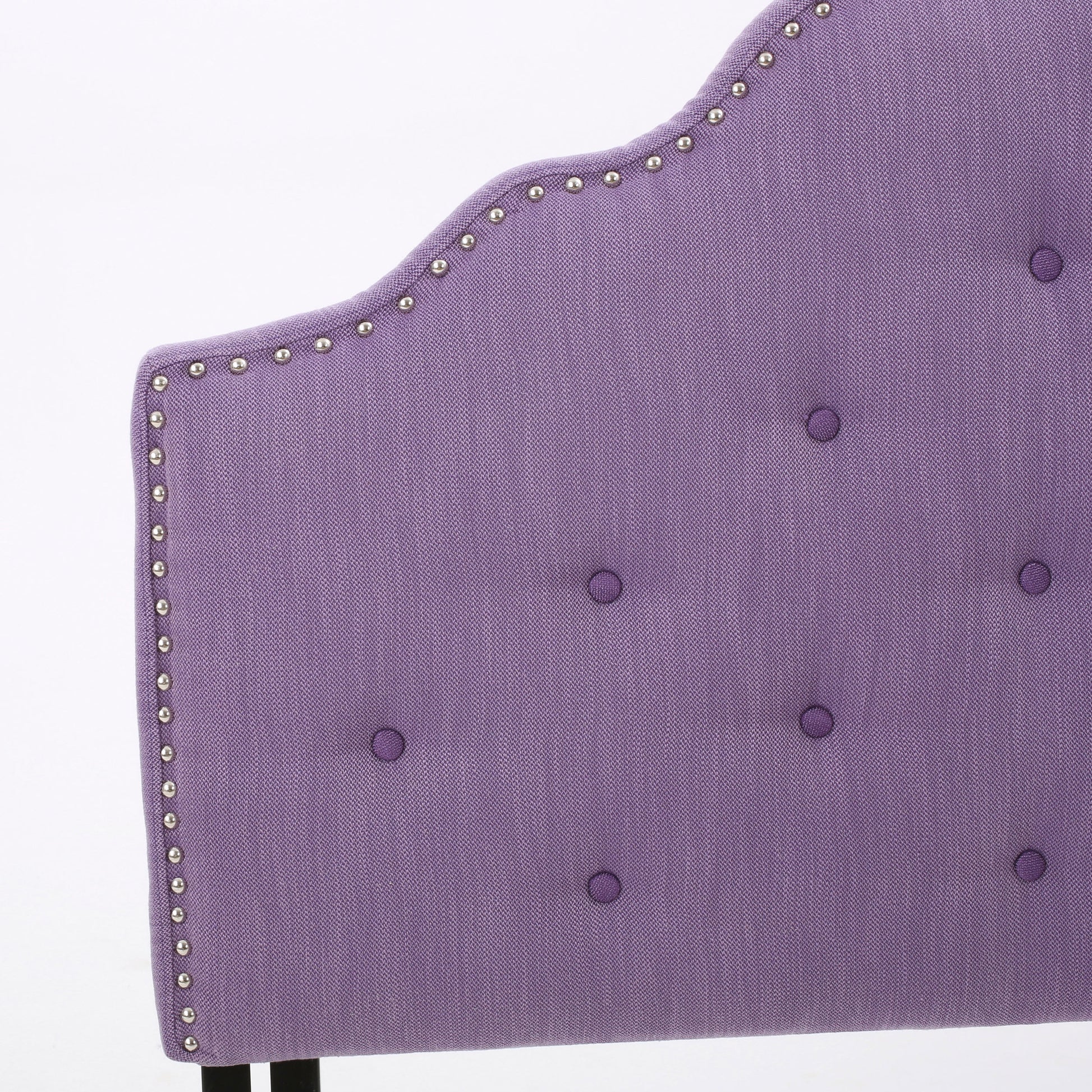 Purple tufted headboard with nailhead trim detail