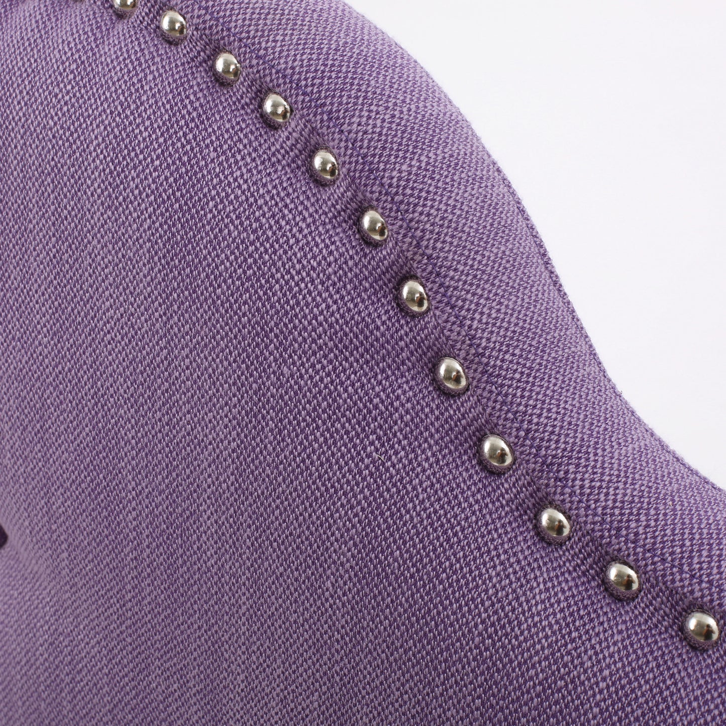 Closeup of tufted purple fabric accent on a piece of furniture