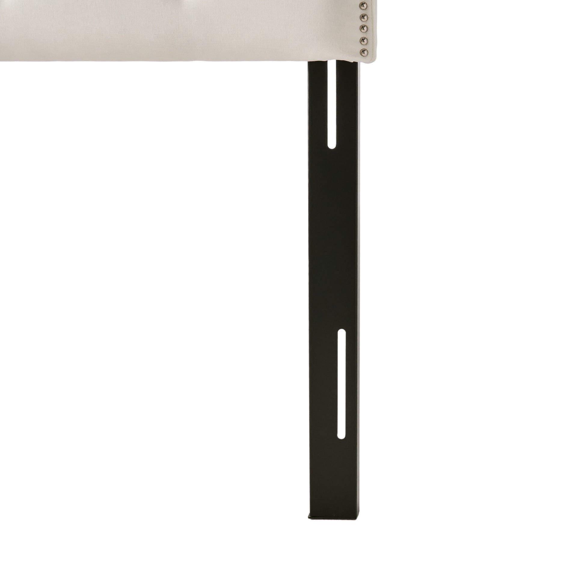 Tufted beige headboard with silver nailhead trim and black metal bed frame legs