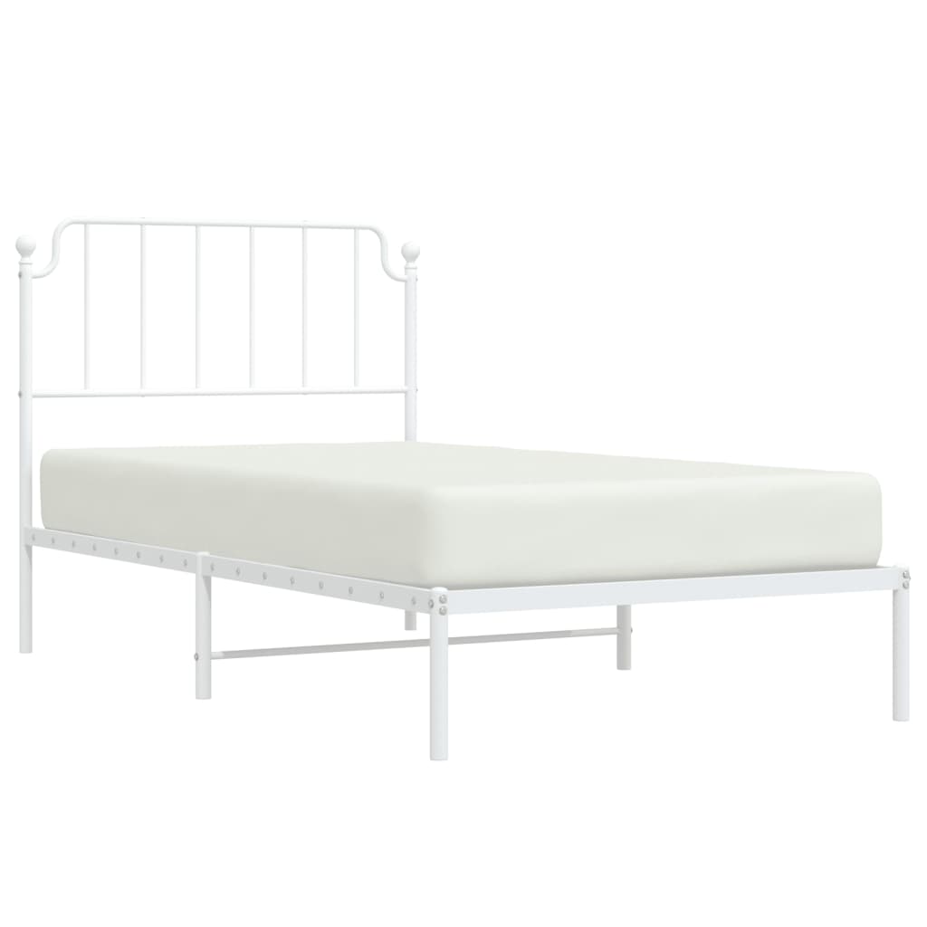 White metal twin bed frame with ornate headboard and mattress