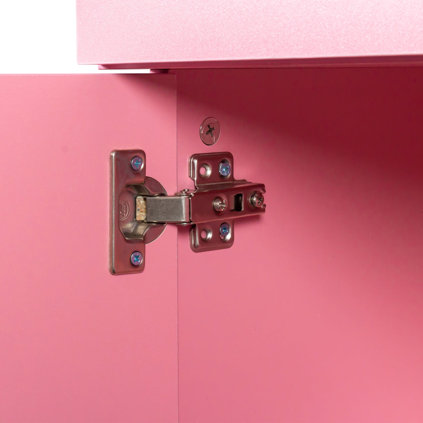 Closeup of a metal cabinet hinge with blue screws on a pink MDF door