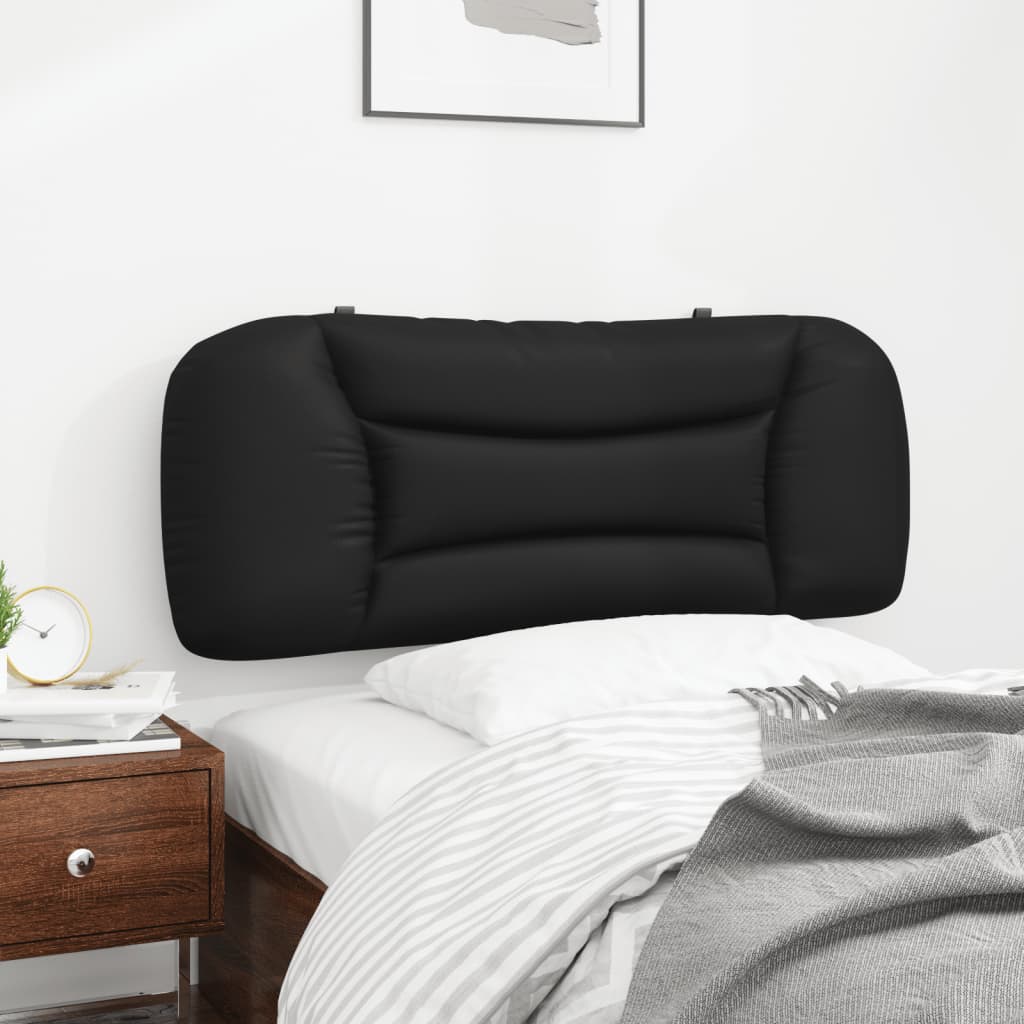 Black tufted headboard with curved sides on a bed with white bedding