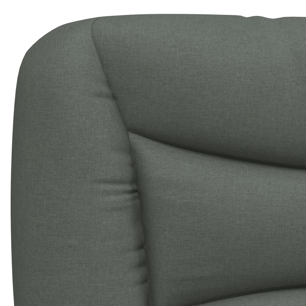Closeup of a grey upholstered bed frame with a wooden slat base and a black cylindrical leg