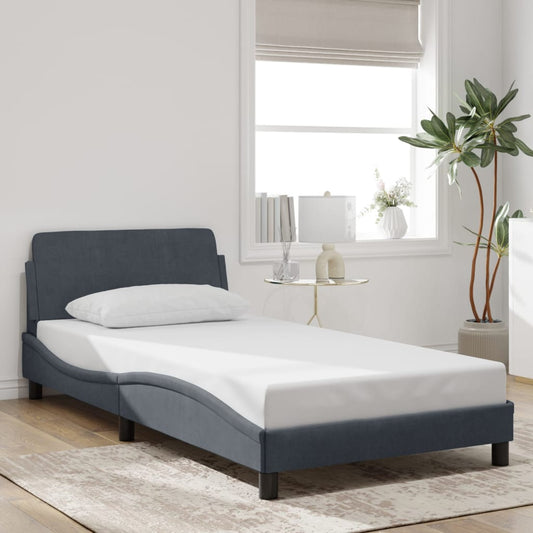 Dark blue upholstered twin bed frame with a white mattress and pillow