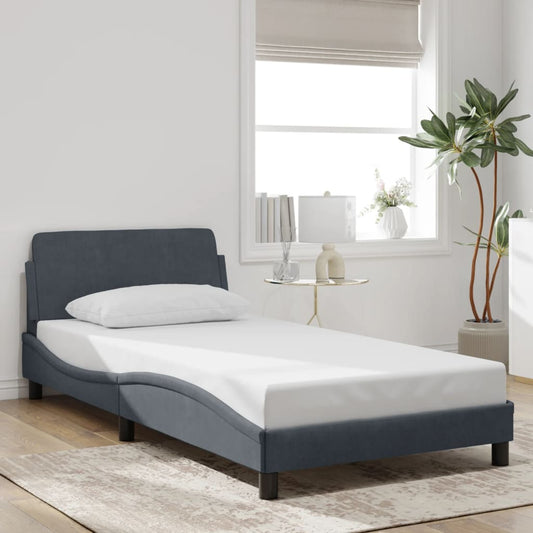 Dark gray upholstered single bed frame with white mattress and pillow
