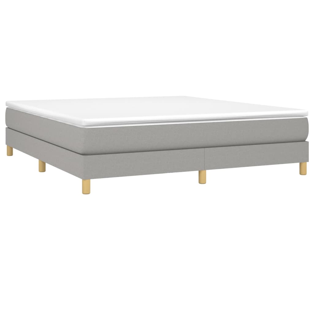 Grey upholstered divan bed base with wooden legs