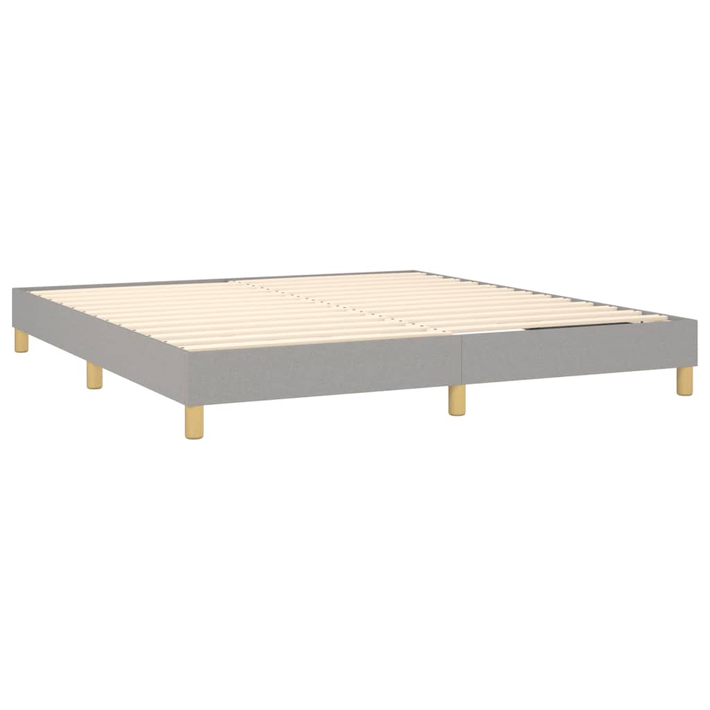 Gray upholstered bed frame with a white mattress and wooden legs