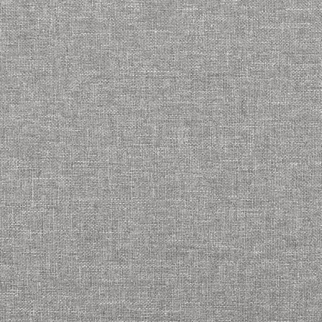 Closeup of grey fabric upholstered bed frame with light wood slats and gold cylindrical legs