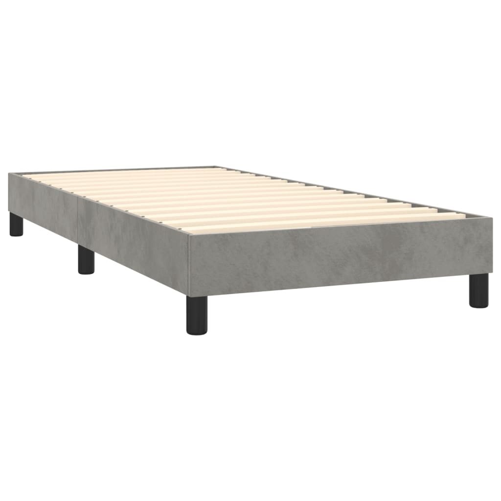 Grey upholstered divan bed base with white mattress