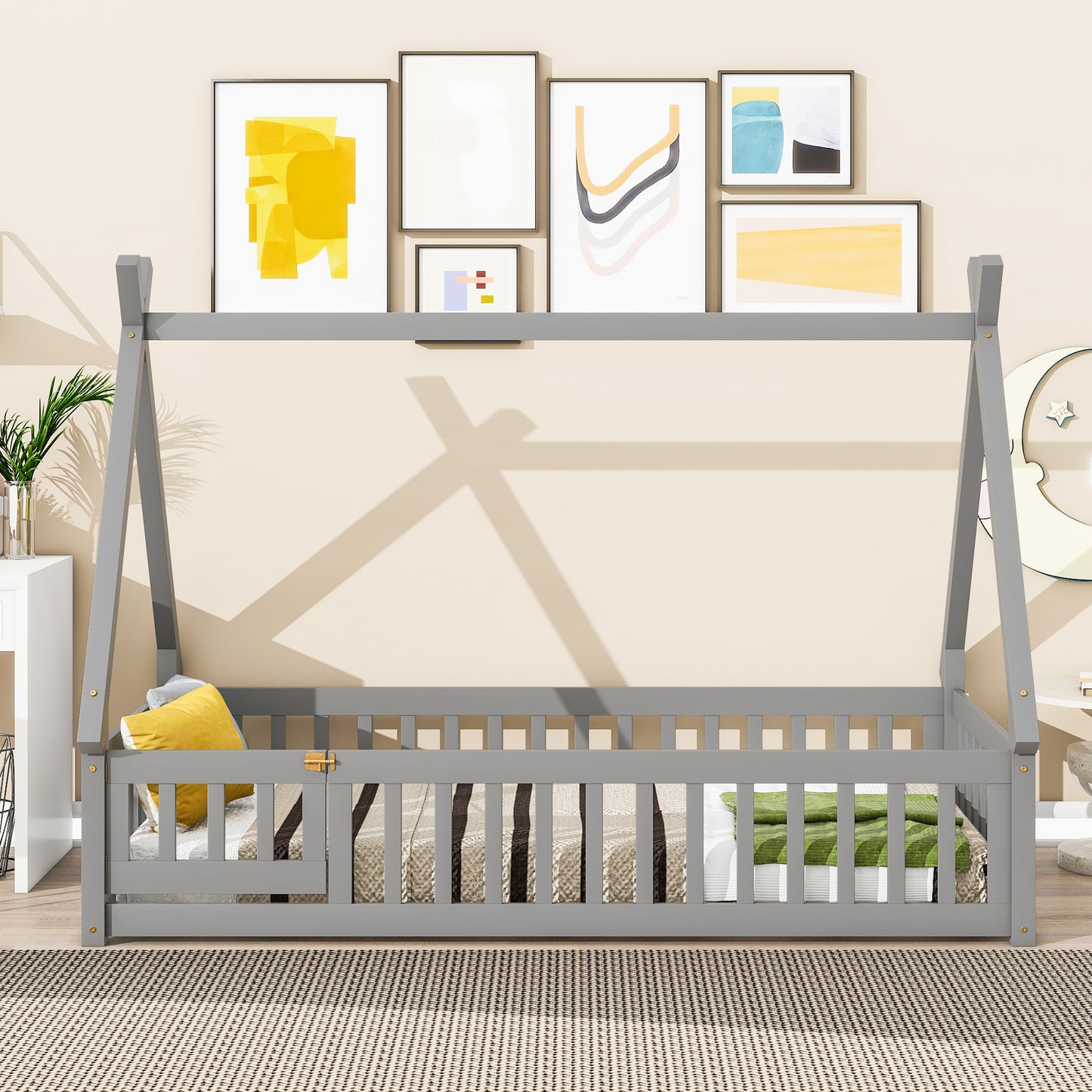 Gray wooden toddler bed frame with railings and yellow accent pillow