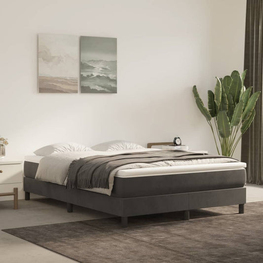 Dark grey upholstered bed frame with a white mattress and grey throw blanket