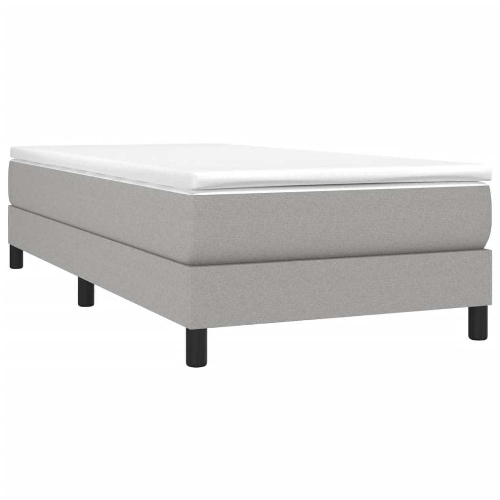 Gray upholstered single bed frame with white mattress topper