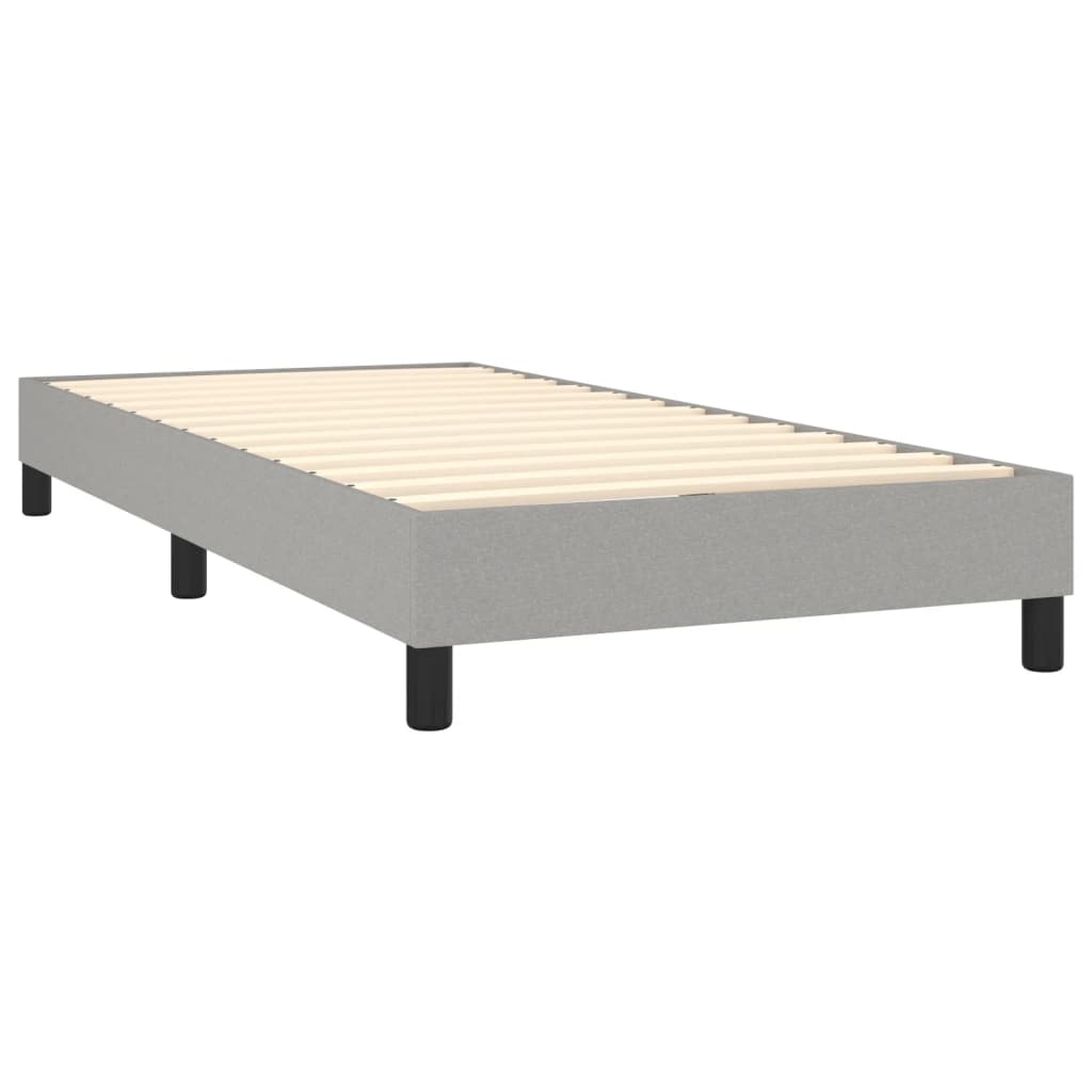 Single grey fabric divan bed base with a white mattress topper and black legs