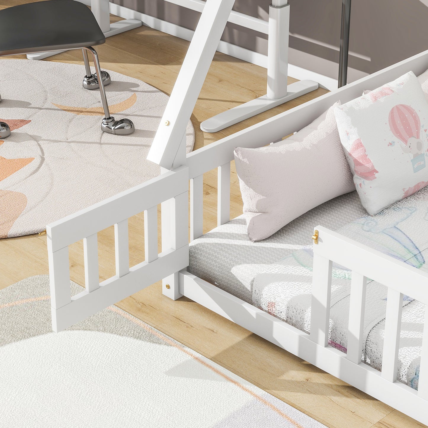 White wooden toddler bed with railings and cartoon bedding