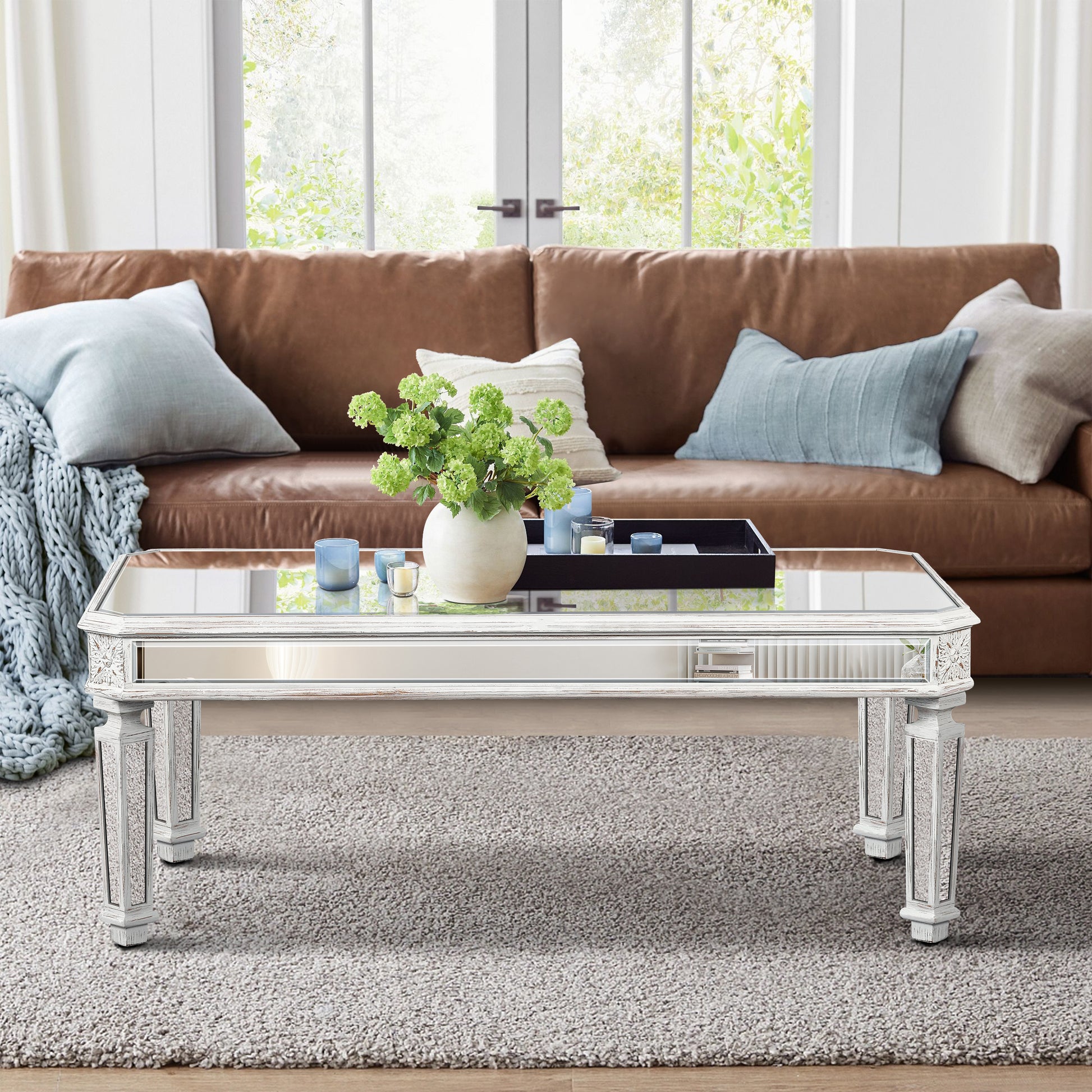 Mirrored coffee table with distressed white wood frame and ornate carvings
