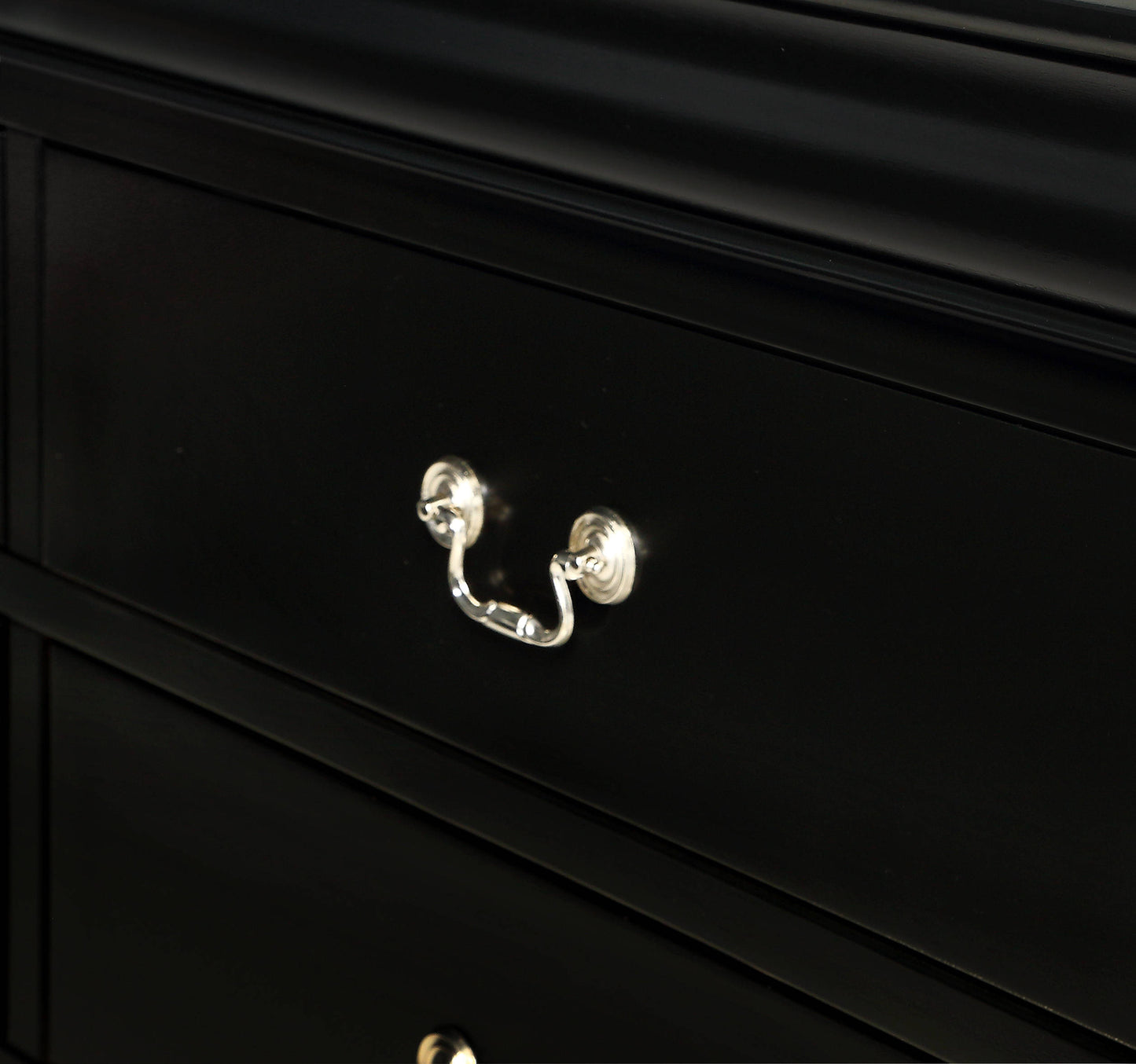 Black wooden dresser drawer with ornate silver pull