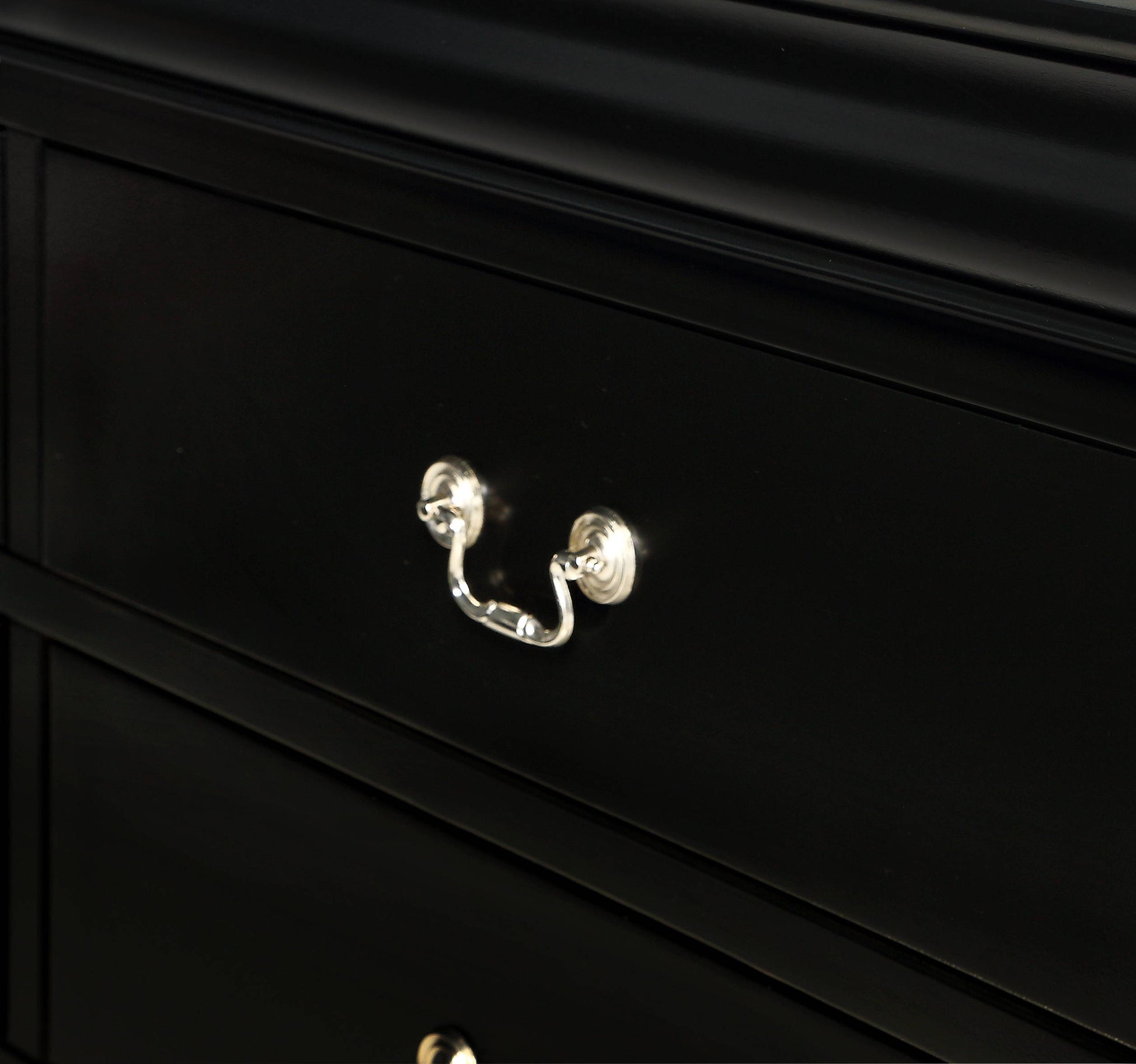 Black wooden dresser drawer with ornate silver pull