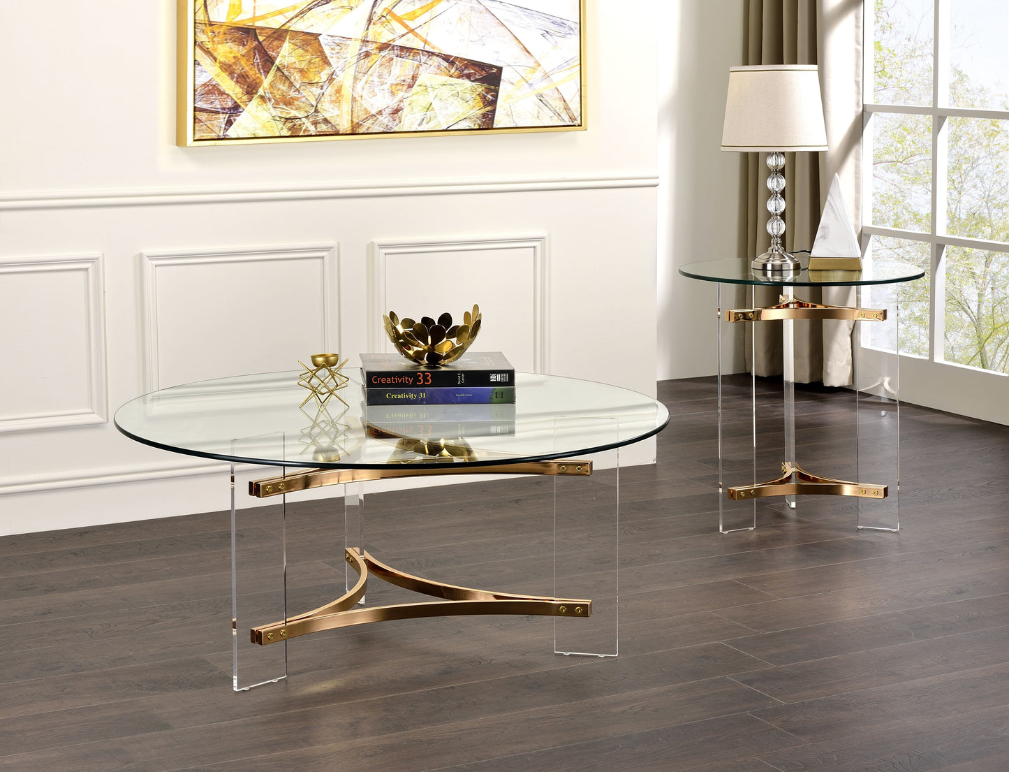 Round glass coffee table with brass accents and acrylic legs