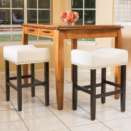 White upholstered bar stool with silver nailhead trim and dark wood legs