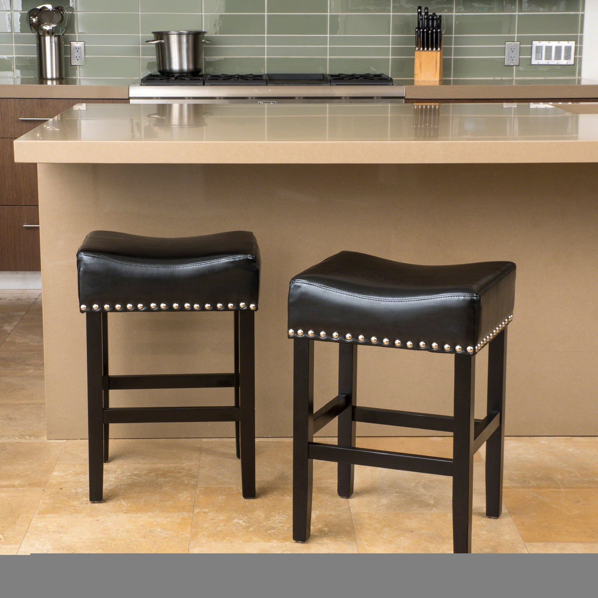Pair of black faux leather bar stools with silver nailhead trim and dark wood legs