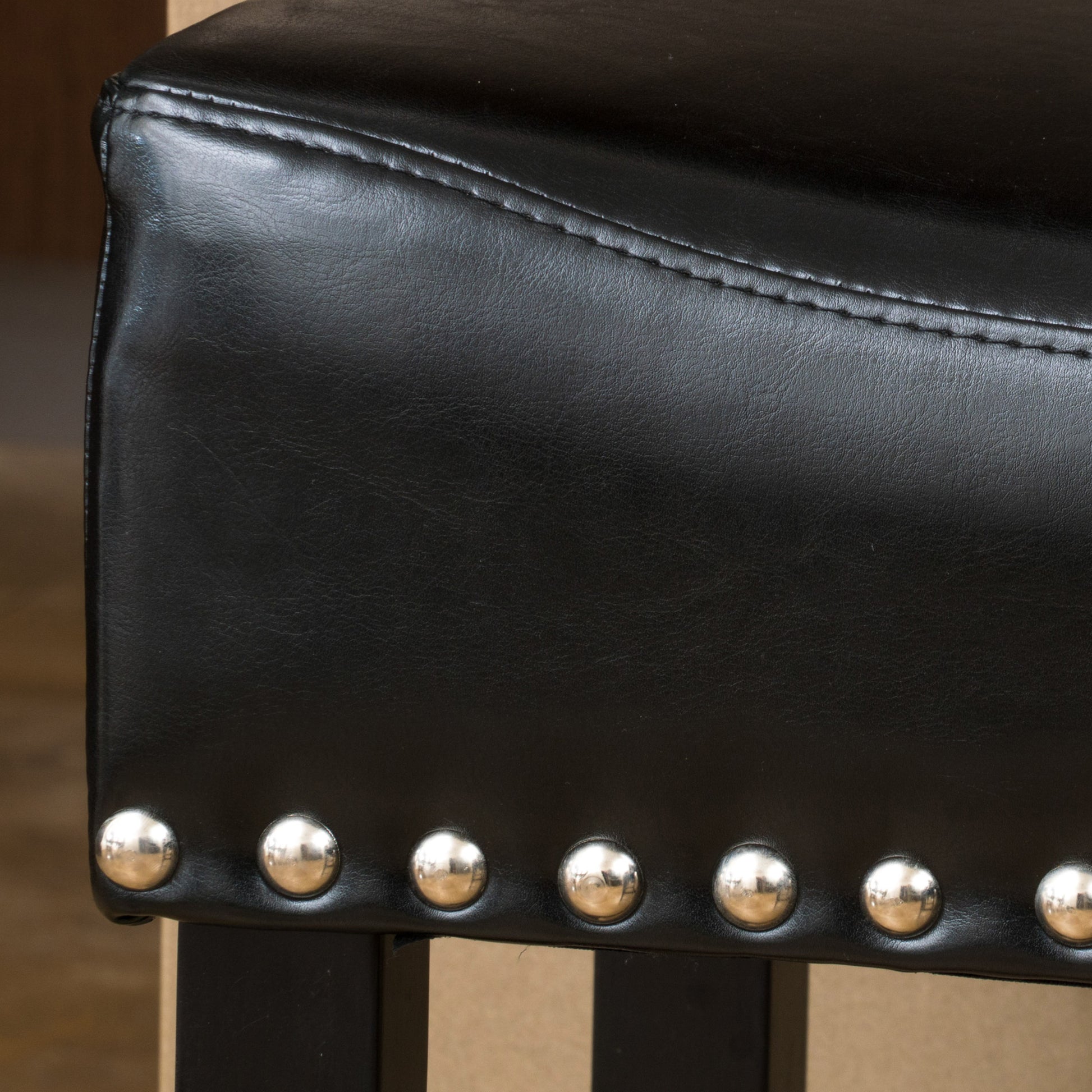 Black faux leather ottoman with polished metal studs