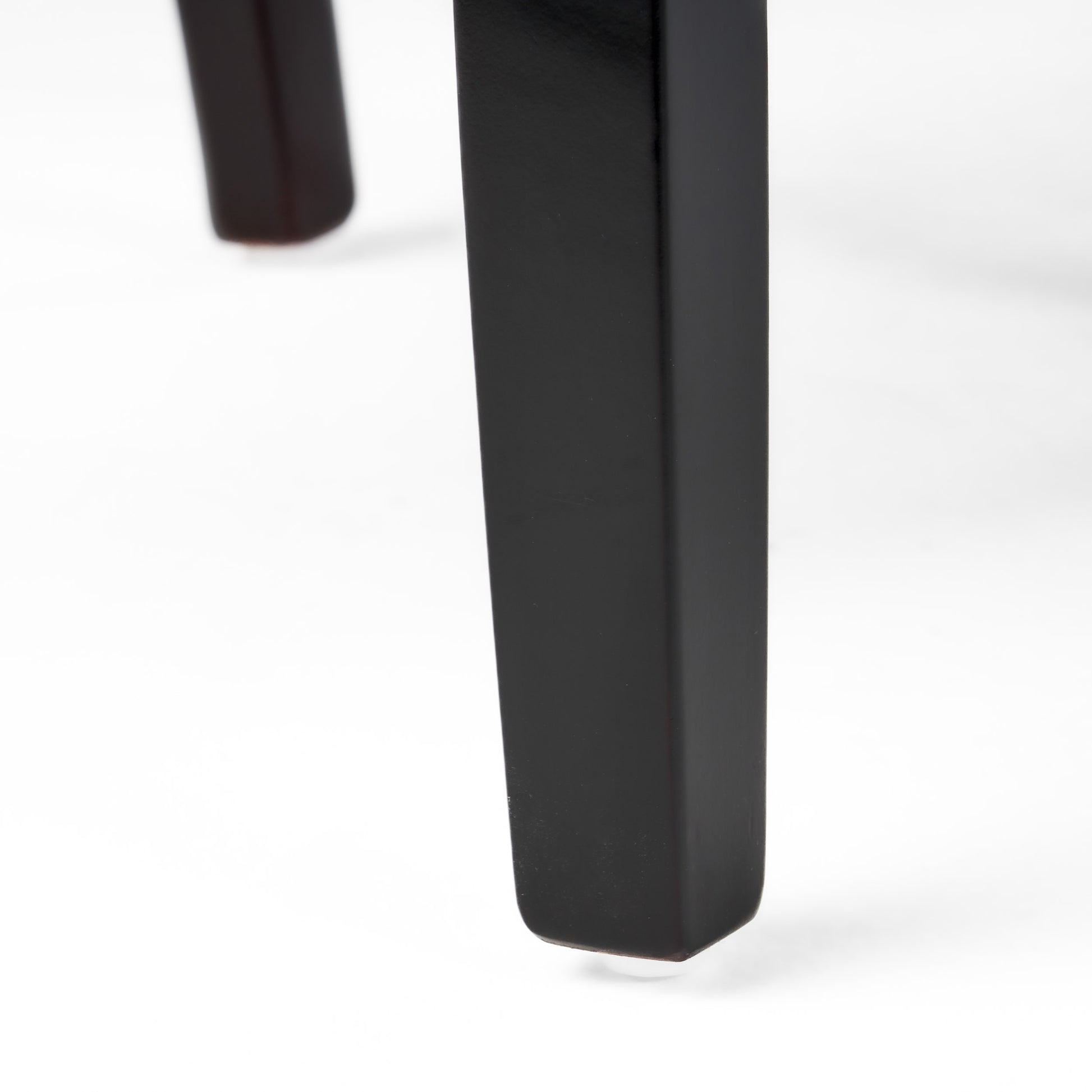 Dark wood chair leg with clear floor protector on white background