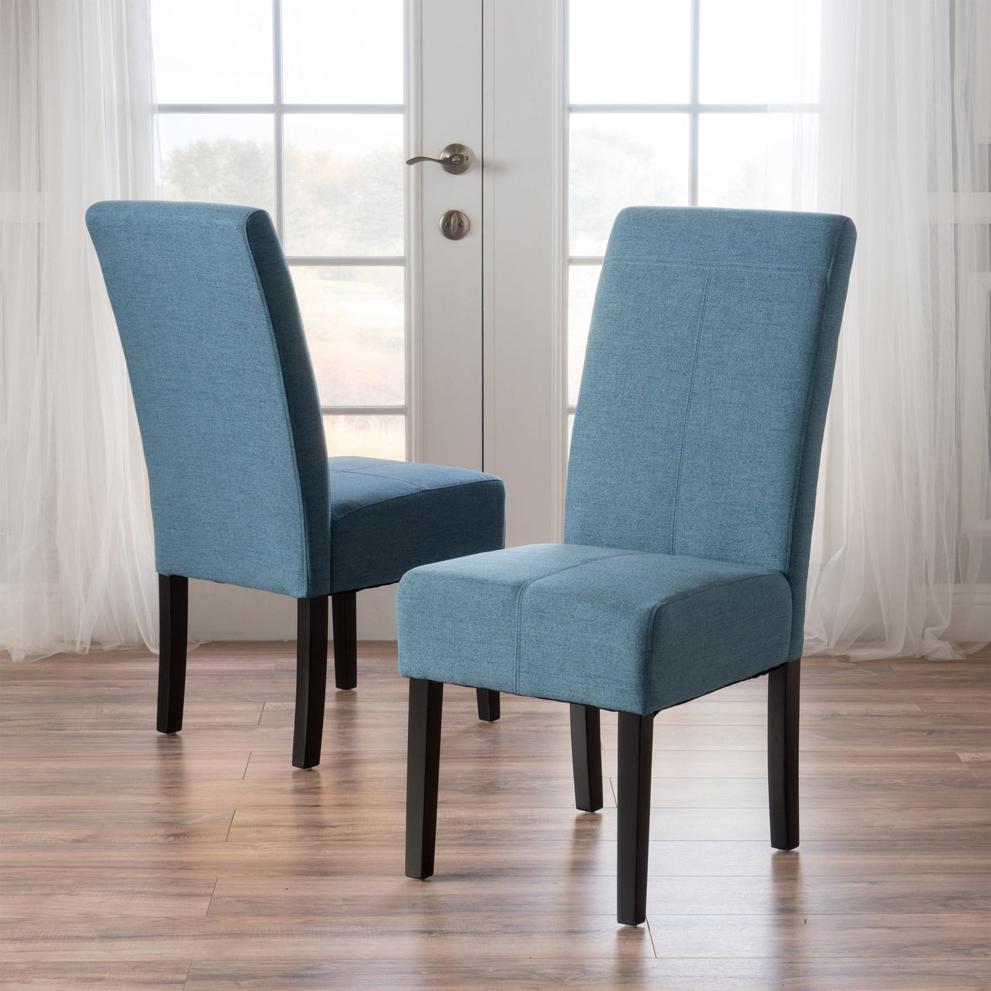 Two blue upholstered dining chairs with dark wooden legs