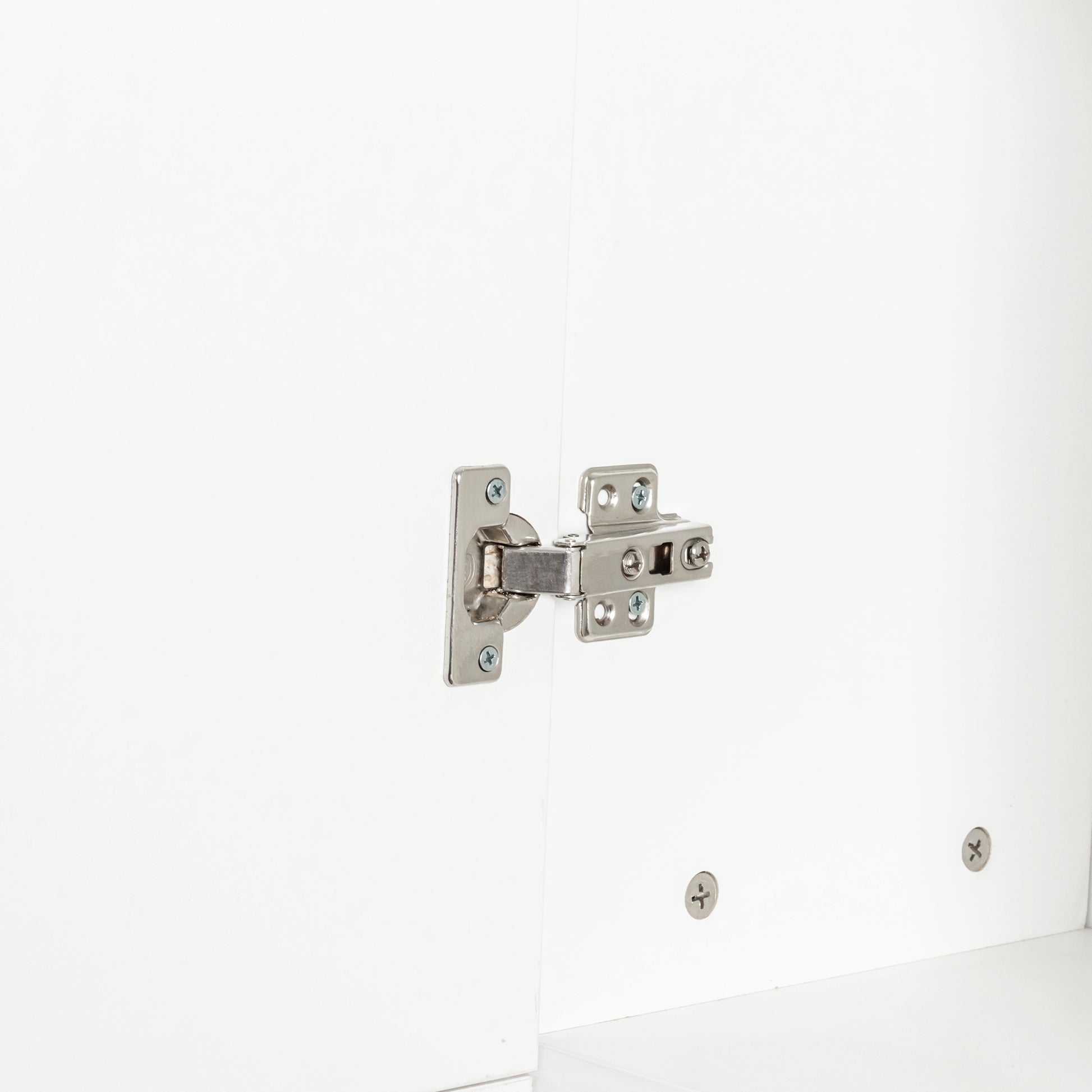 Closeup of silver concealed cabinet hinge on white surface