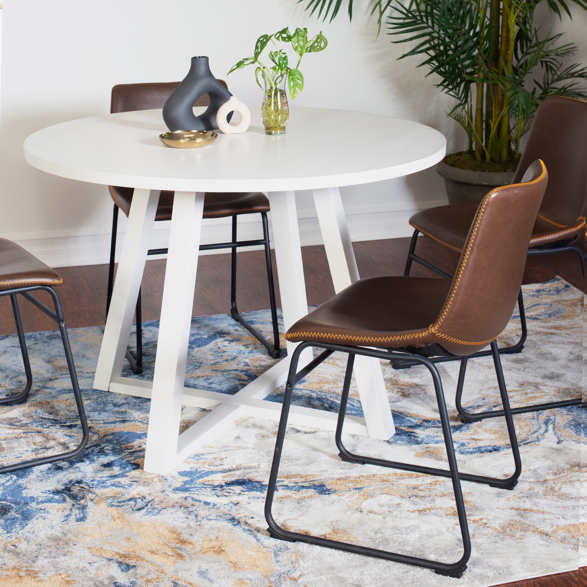 Round white dining table with black metal leg base