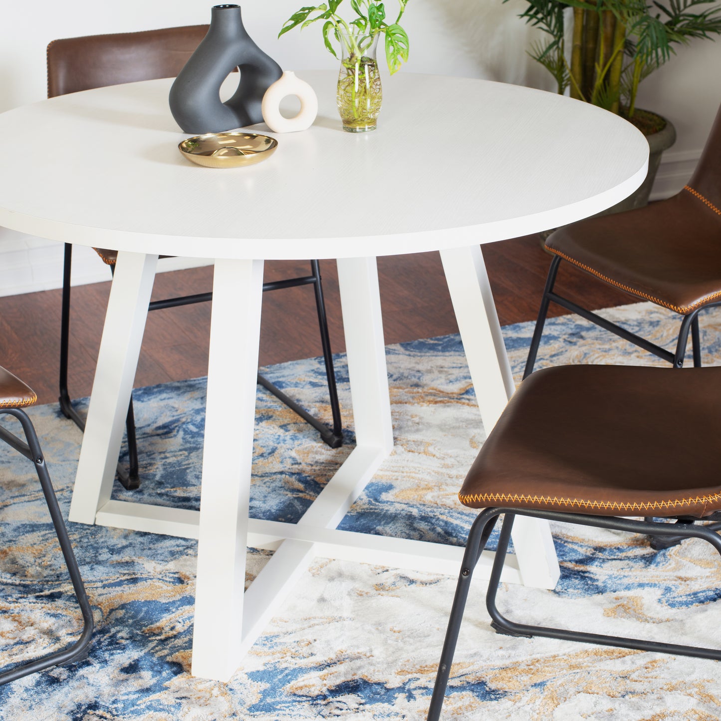 Modern white round dining table with a matte finish and geometric base
