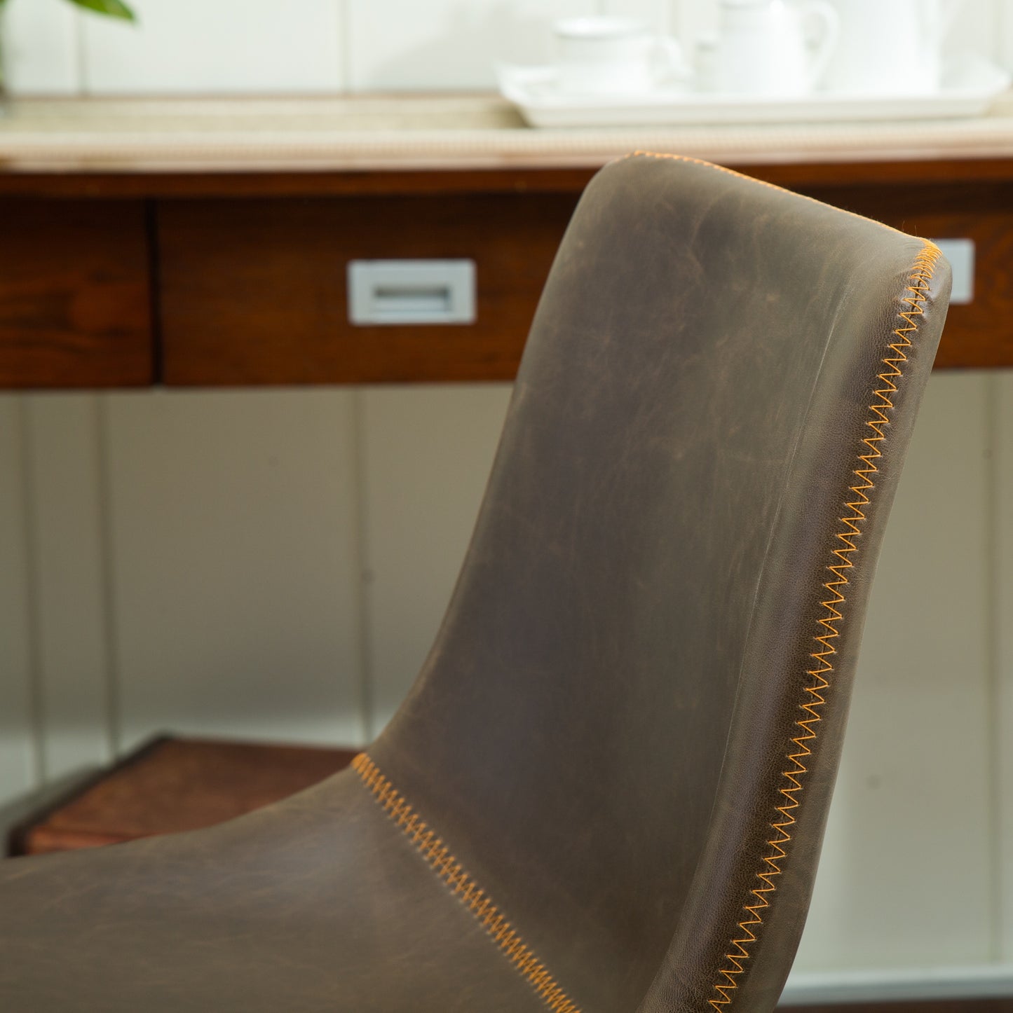 Brown leather accent chair with orange stitching detail