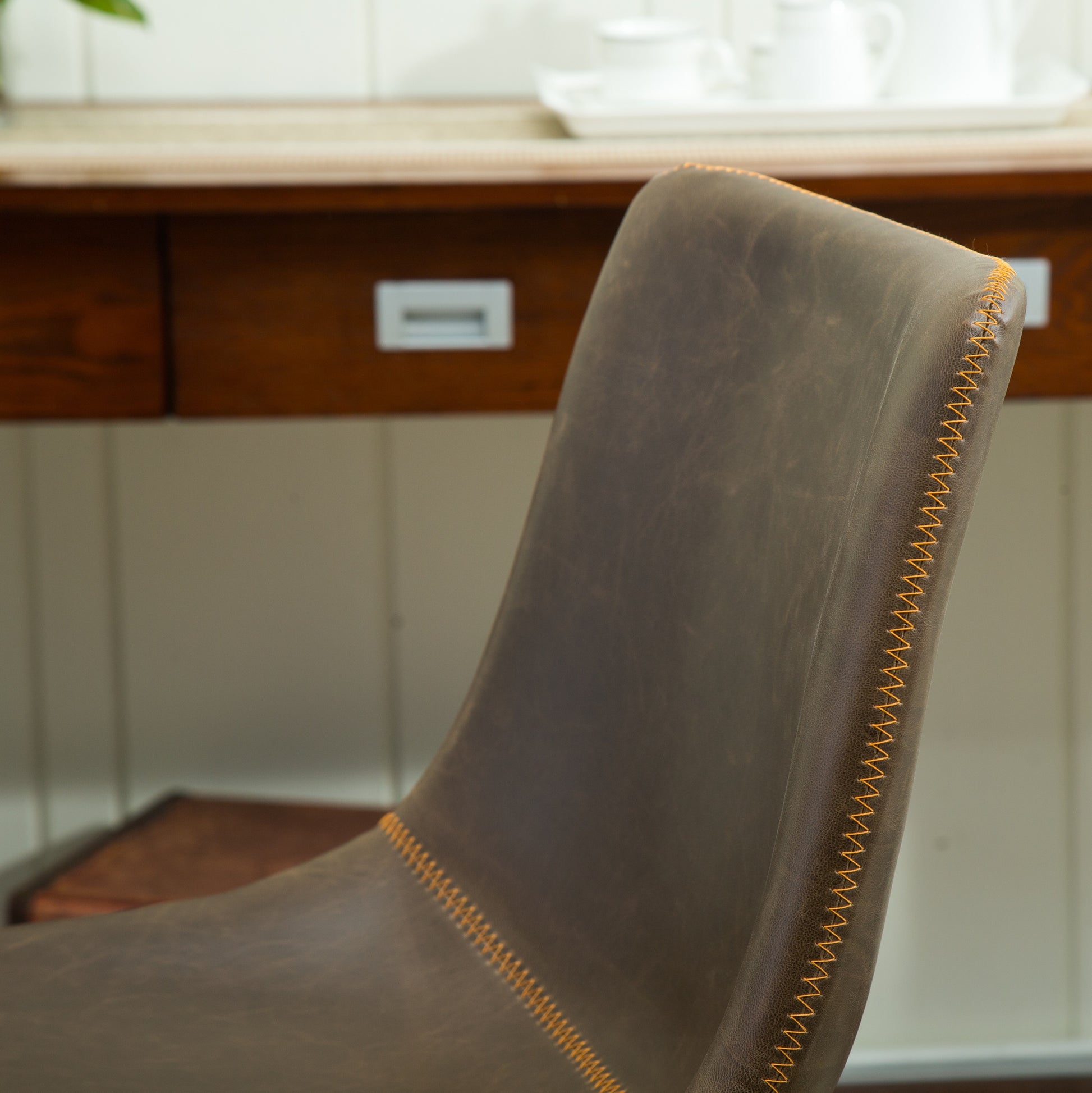 Brown leather accent chair with orange stitching detail
