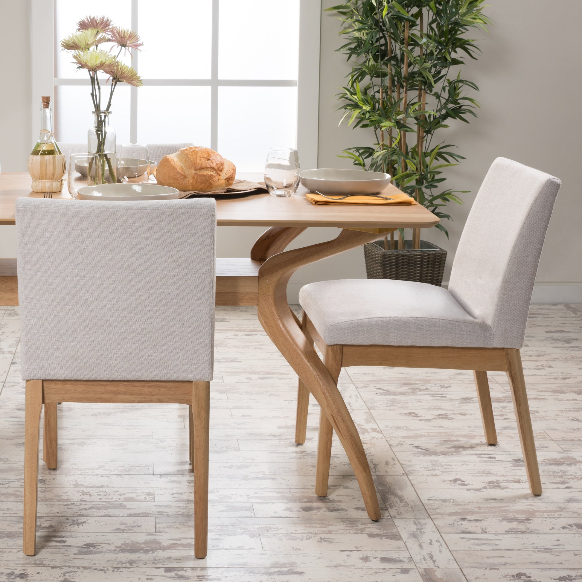 Light beige upholstered dining chairs with natural wood legs