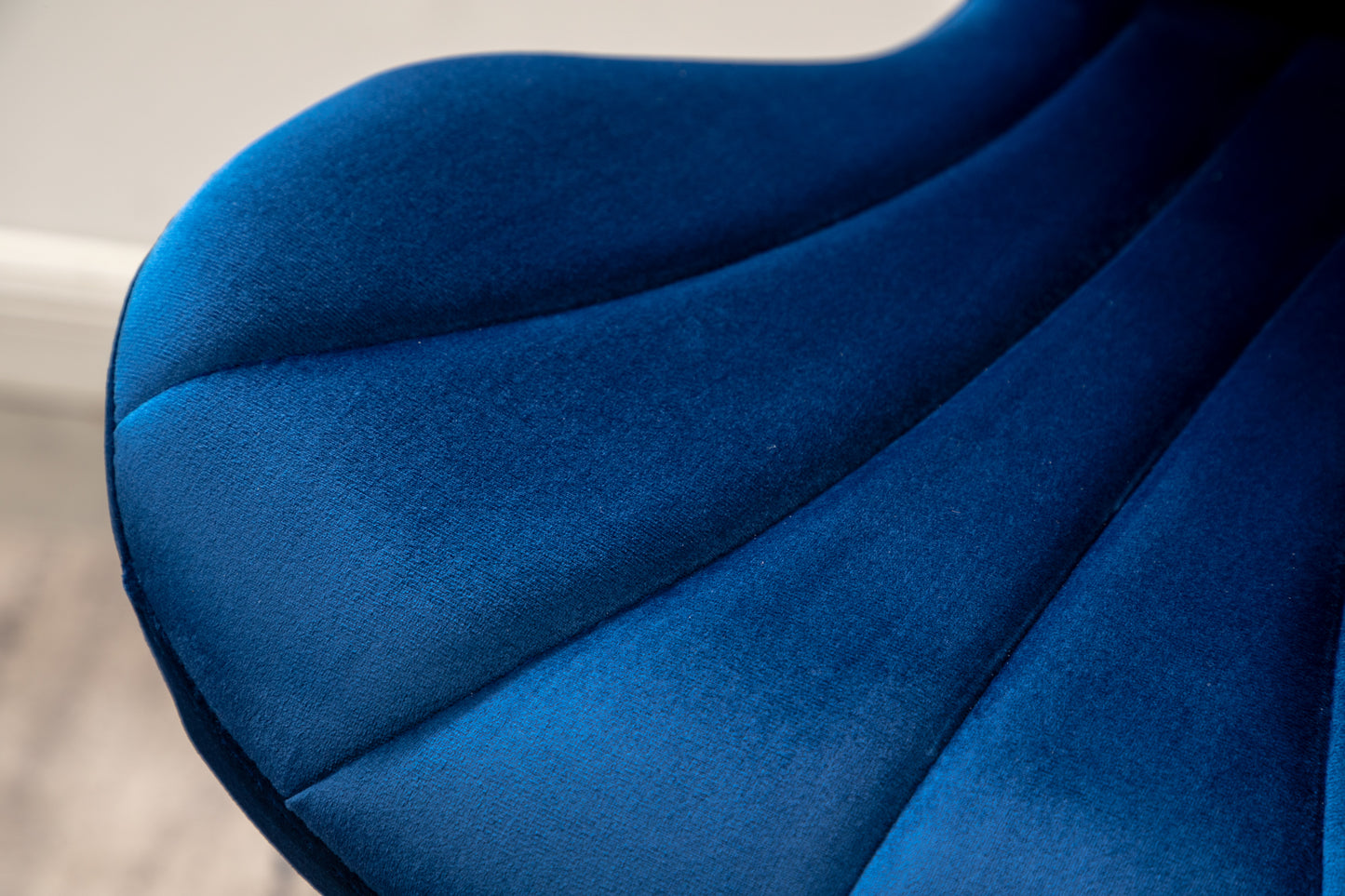 Deep blue velvet upholstered chair detail with channel stitching