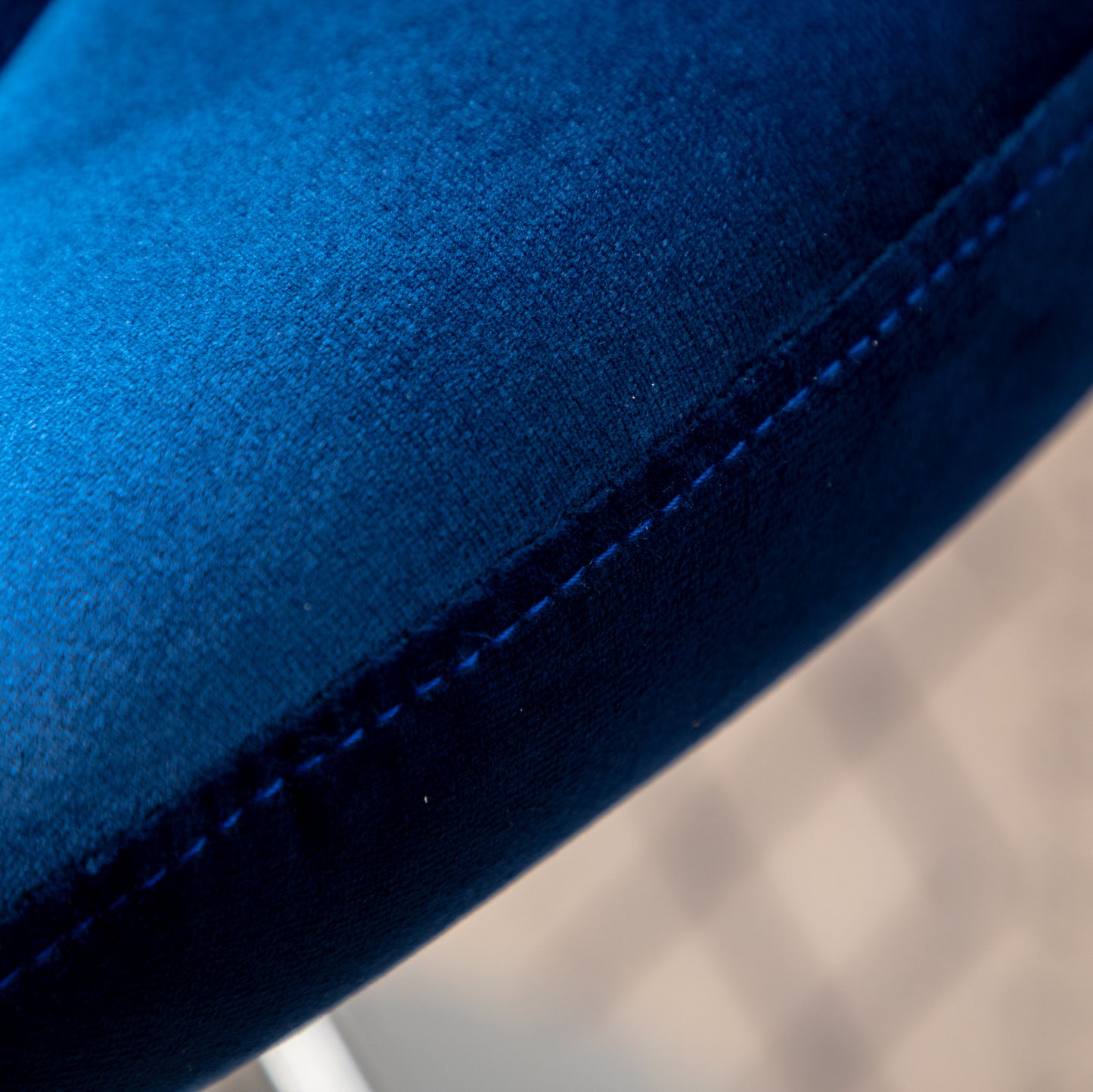 Closeup of plush navy blue velvet fabric with subtle stitching detail